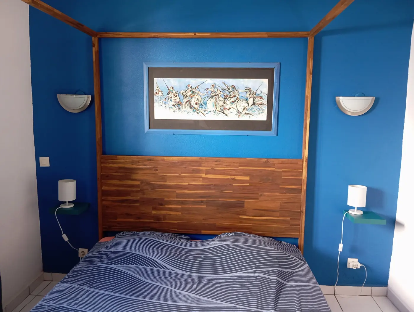 Chambre climatisée avec lit à baldaquin en bois et murs bleus