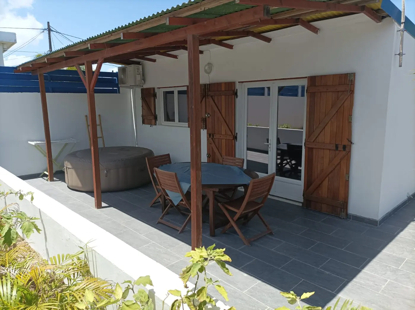 Terrasse couverte avec table, chaises et spa gonflable